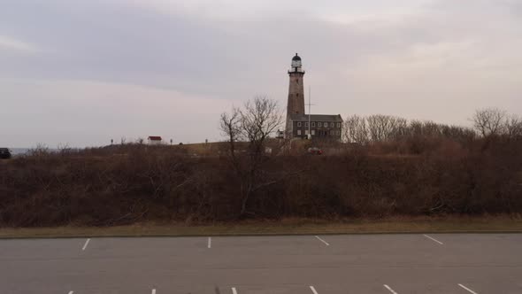 A low angle drone view of the Montauk lighthouse during a cloudy sunset. The camera dolly in and boo