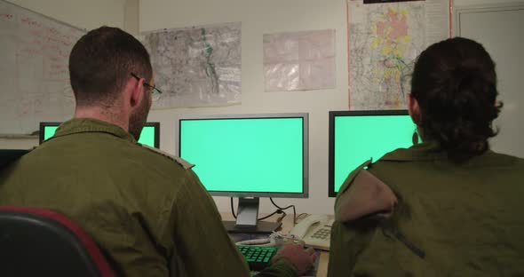 Israeli soldiers in a military command and control room looking at screens