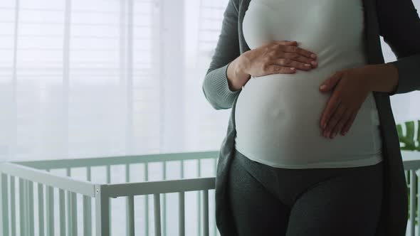 Close up video of pregnant woman stroking advanced pregnant abdomen