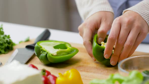 Woman Cutting Pepper in Half and Removing Seeds