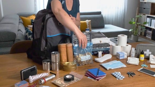 Woman putting food to prepare emergency backpack