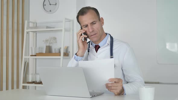 Doctor Talking on Phone with Patient, Discussing Medical Report