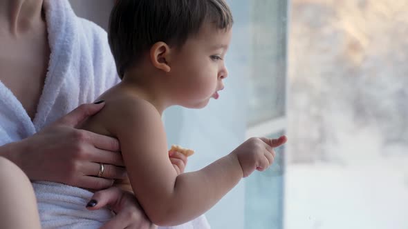 Mom and Son Sitting on the Window in a Bathrobe