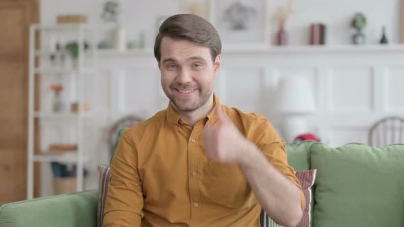 Portrait of Young Man Showing Thumbs Up at Home