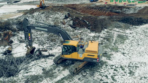 Yellow Excavator Works with Stones at a Quarry.