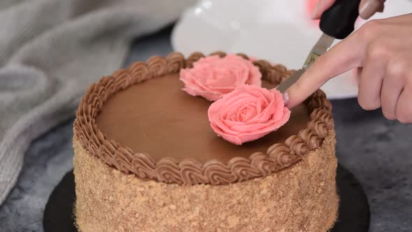 Pastry Chef Decorates the Cake with Flowers From the Cream