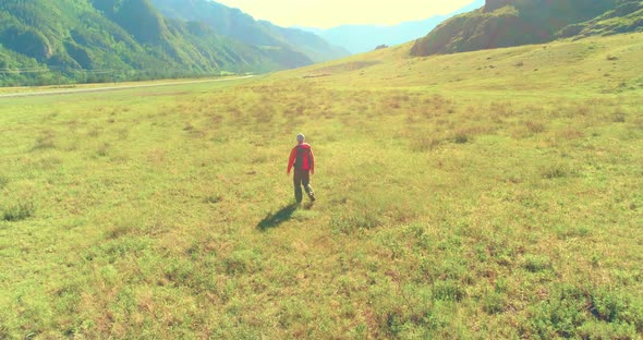 Flight Over Backpack Hiking Tourist Walking Across Green Mountain Field