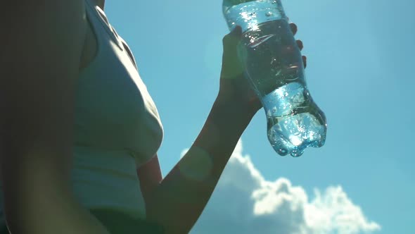 Sporty Woman Drinking Water Outdoor on Sunny Day