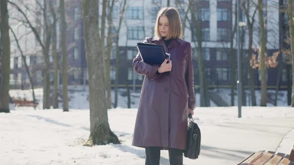 Busy Young Businesswoman Sighing Walking Away on Cold Winter Day in City