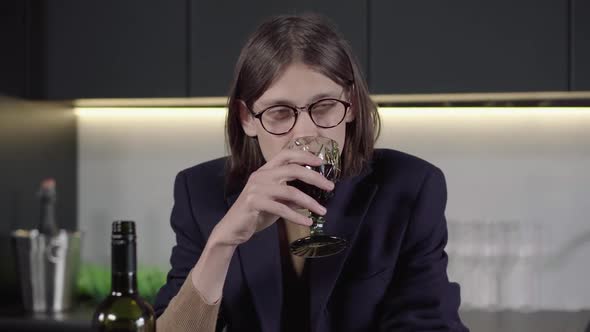 Portrait of Depressed Brunette Man in Eyeglasses Drinking Wine From Glass and Falling on the Table