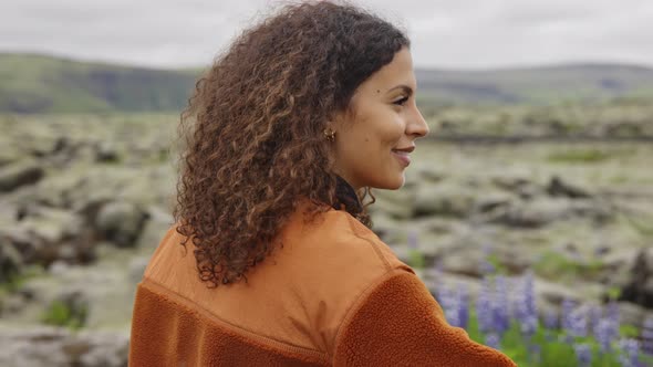 Smiling Young Woman Holding Camera in Icelandic Landscape