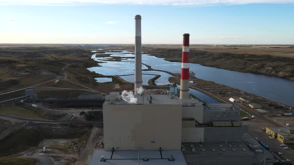 Aerial 4k time lapse of power plant with two high cooling towers next to large blue river in north a