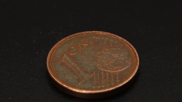 One euro cent copper coin macro shot, rotating close up view in 4k over black surface background.