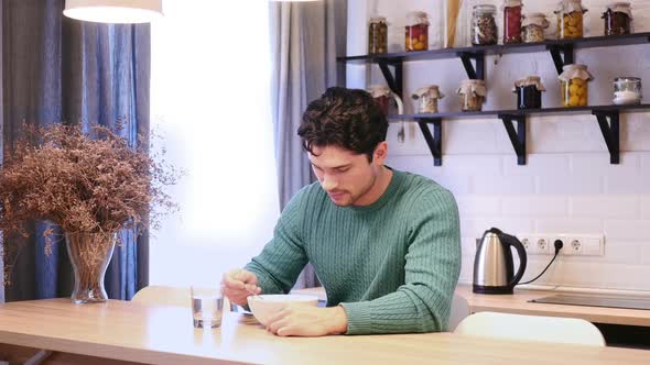 Young Man Eating Food in Kitchen