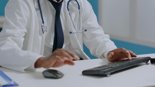 Portrait of African American Therapist Doctor Sitting at Desk in Hospital Office