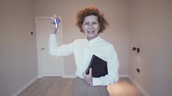 Real Estate Senior Saleswoman Holding the Keys to New Apartment