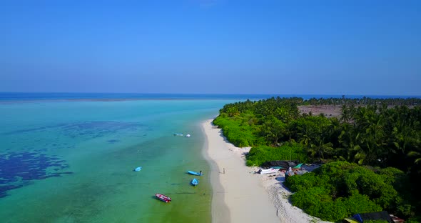 Wide aerial clean view of a white sand paradise beach and aqua blue water background in vibrant