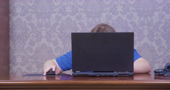 Man is Hard Working or Playing Video Game Hiding Behind Laptop