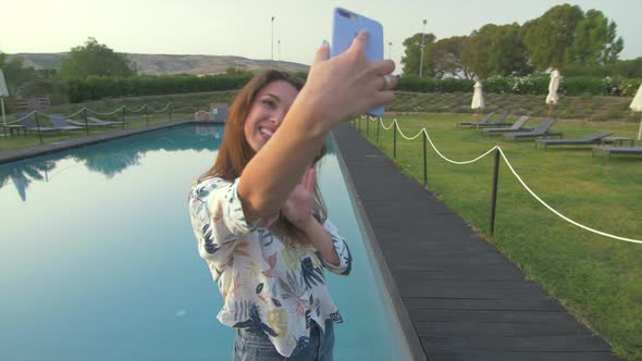 Beautiful woman making selfie mobile photo on nice luxury villa