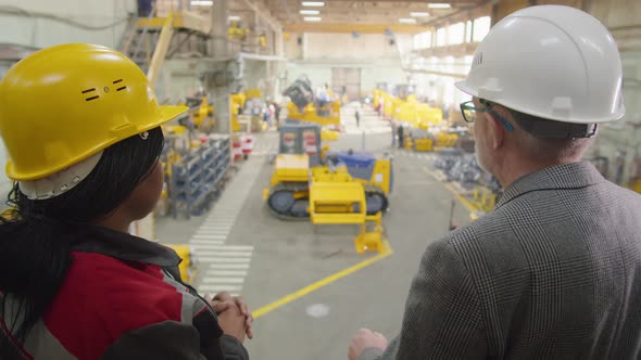 Engineer Speaking with Female Worker in Factory