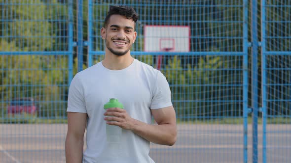 Happy Successful Middle Eastern Indian Man Athlete Latino Runner Holding Sports Bottle of Clean