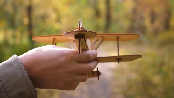 The Guy Holds a Plane in His Hand Simulates Flight