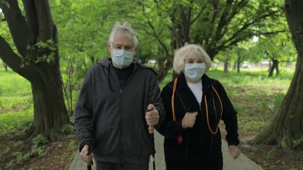 Active Senior Old Man, Woman Training Nordic Walking in Park During Quarantine