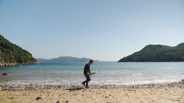 Environmental activist collecting plastic on a beach clean up due to global warming and ocean destru