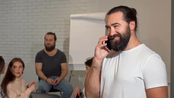 Bearded Mature Businessman Talking in the Phone Joyfully