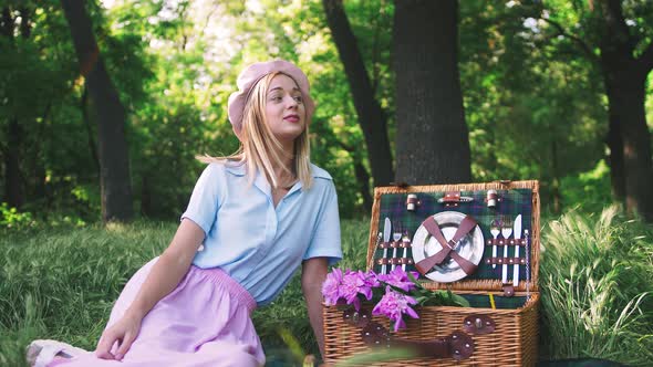 Portrait of Happy Romantic Young Woman with a Bouquet of Flowers Outdoors in Park on Picnic