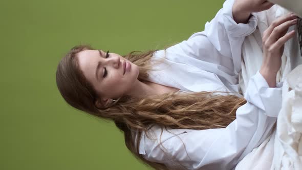 Young Girl Uses Laptop While Sitting On Bed In Apartment