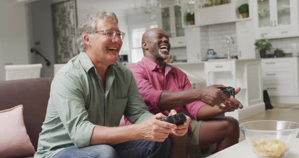 Animation of happy diverse male senior friends playing video games