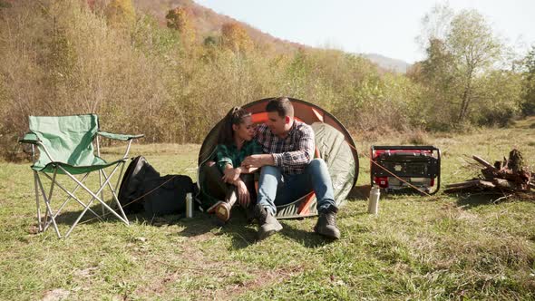 Beautiful Young Couple Having a Conversation in Front of Their Camping Tent
