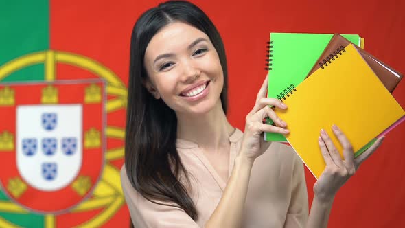 Happy Student Showing Notebooks Portuguese Flag Background, Language Tutor