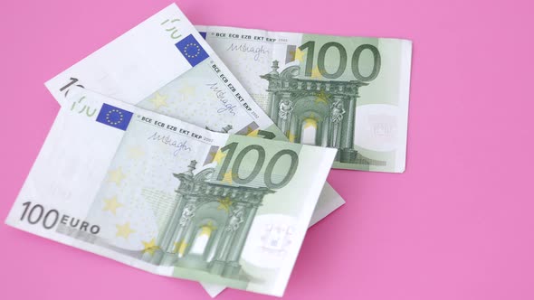 100 euro bills on pink background. close-up