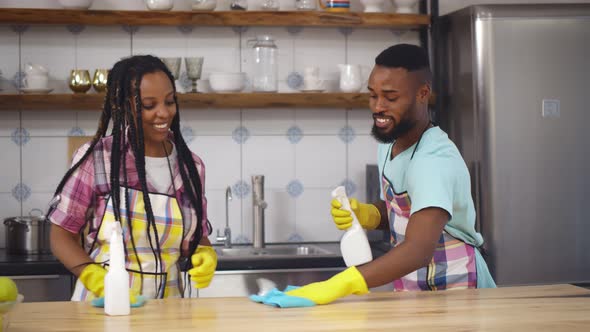 Young African Family Couple Doing Cleaning in Kitchen