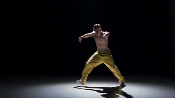 Breakdance Dancer in Yellow Suit with Naked Torso Dance on Black, Shadow