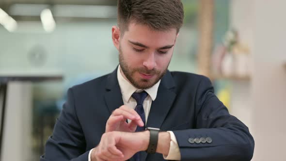 Young Businesswoman Using Smartwatch at Work