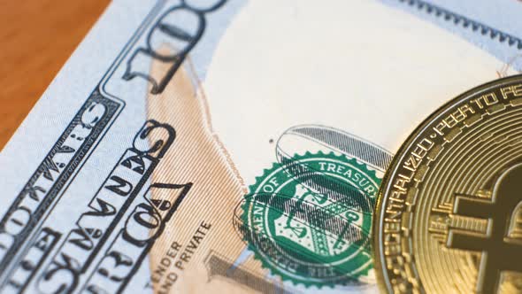 Close Up of Metal Shiny Bitcoin Crypto Currency Coin on US Dollar Bills