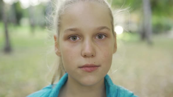 Portrait of a Young Irritated Blond Girl Looking at the Camera. Pretty Caucasian Teen Standing