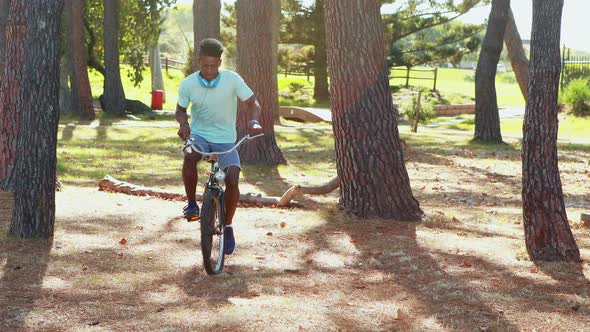 Man with headphones riding bicycle in the park 4k