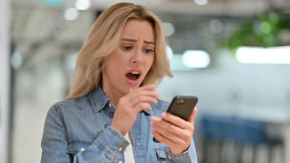 Young Casual Woman Reacting To Failure on Smartphone 