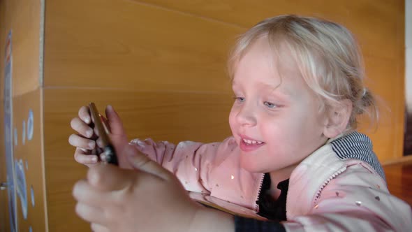 Little girl is getting acquainted with selfie