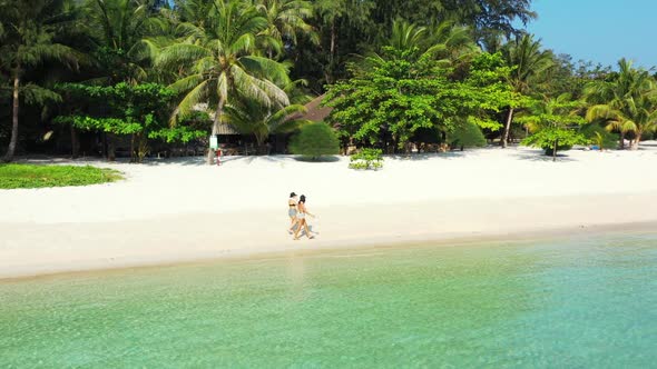 Tourists enjoying life on beautiful sea view beach trip by aqua blue water and white sandy backgroun