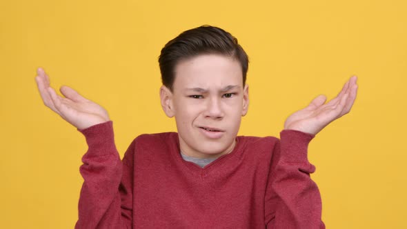 Teenager Boy Shrugging Shoulders Shaking Head In Disagreement Yellow Background