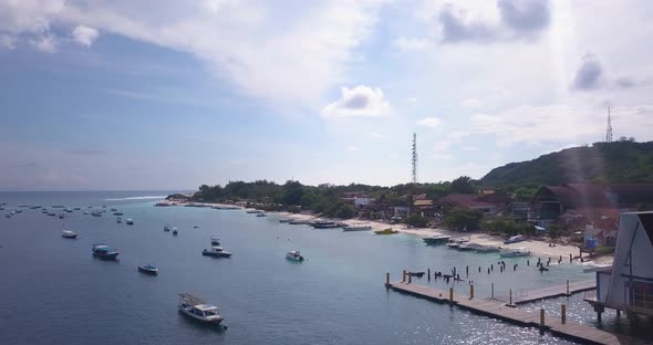 Boats moored in sea at Gili Trawangan pier, tropical island, aerial panoramic