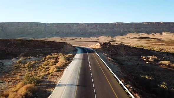 aerial: drone view over a deserted road in the middle of the Ramon crater canyons, Makhtesh Ramon in