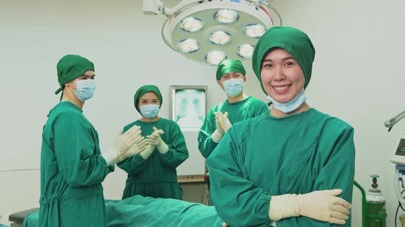 Asian professional surgeons and nurses suture feeling glad and clap hands after successful operation