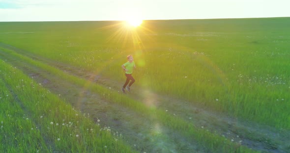 Sporty Child Runs Through a Green Wheat Field