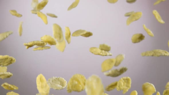 Cereal Corn Flakes are Flying Up and Rotating on the White Background